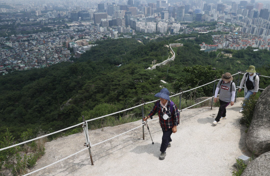 코로나19 백신 접종자에게 등산로와 공원 등 실외 공간에서 마스크 미착용이 허용된 1일 인왕산 등산로에 백신을 접종한 중년 여성이 마스크를 목에 걸고 등산을 하고 있다. 뒤따르는 이들은 여성의 딸들이며, 아직 백신 접종을 하지 않았다. 연합뉴스